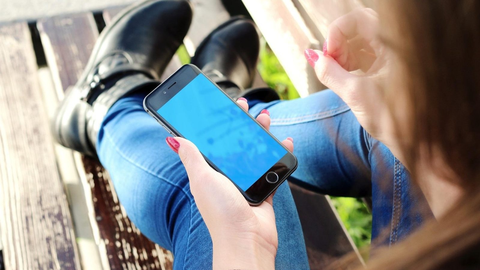 深色背景上手机屏幕亮起牌游戏 App 主界面，桌面上散落着扑克牌与笔记，暖色灯光营造专注对局的氛围